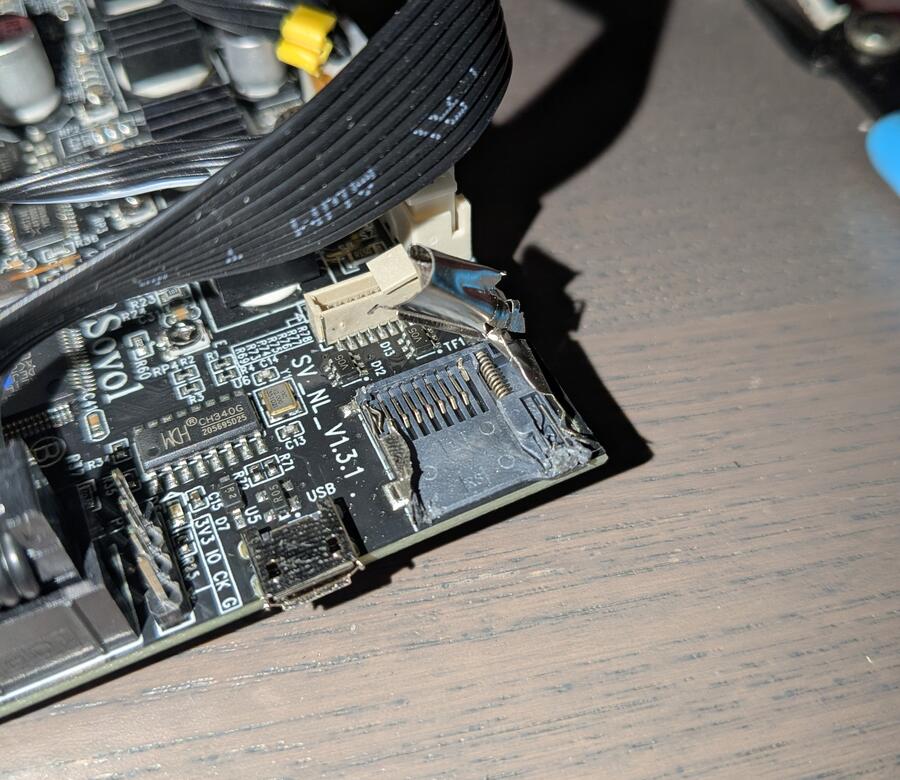 A 3D printer control board with the cover of the SD card port peeled back revealing a bent pin.