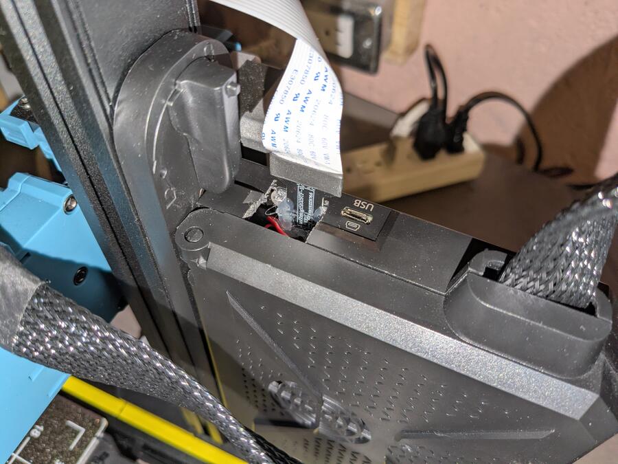 The control board enclosed in its case with the SD card extension sticking out of a newly cut opening.